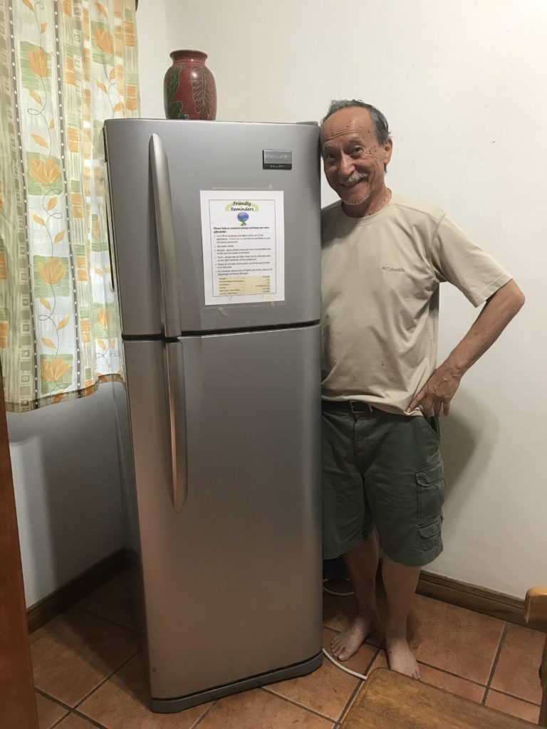 My dad posing by the fridge - which won't fit a pizza box
